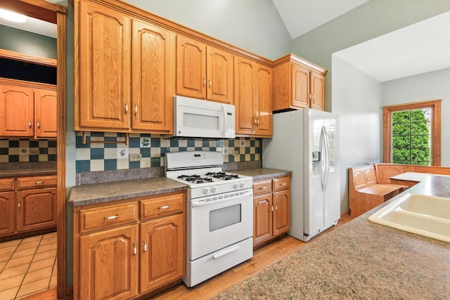 3664 E 2619th Rd, Sheridan, IL 60551 - kitchen featuring white appliances, lofted ceiling, decorative backsplash, brown cabinets, and light wood-style flooring