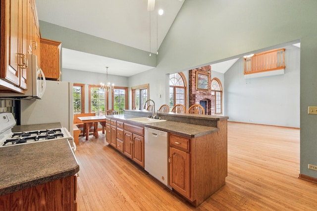 3664 E 2619th Rd, Sheridan, IL 60551 - kitchen with white appliances, a sink, light wood finished floors, a chandelier, and high vaulted ceiling