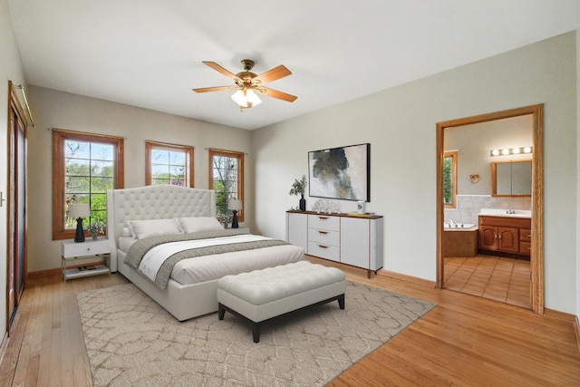3664 E 2619th Rd, Sheridan, IL 60551 - bedroom with light wood finished floors, baseboards, ensuite bath, ceiling fan, and a sink