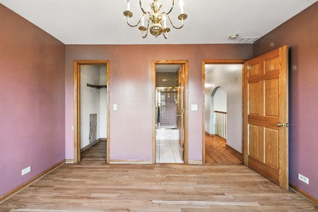 3664 E 2619th Rd, Sheridan, IL 60551 - unfurnished bedroom with light wood-type flooring, a chandelier, baseboards, arched walkways, and ensuite bath