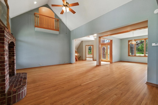 3664 E 2619th Rd, Sheridan, IL 60551 - unfurnished living room featuring light wood-style floors, a brick fireplace, a ceiling fan, high vaulted ceiling, and stairway