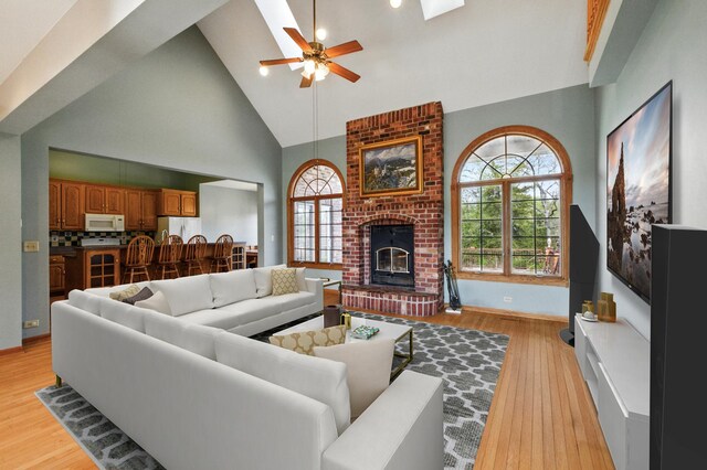 3664 E 2619th Rd, Sheridan, IL 60551 - living area with high vaulted ceiling, a ceiling fan, light wood-style flooring, healthy amount of natural light, and a fireplace