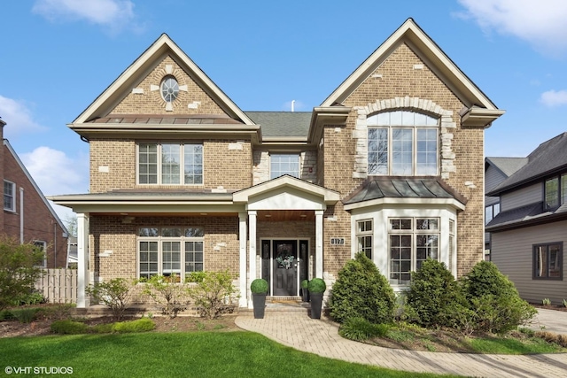 117 Iroquois Dr, Clarendon Hills, IL 60514 - view of front facade with brick siding, a standing seam roof, and metal roof