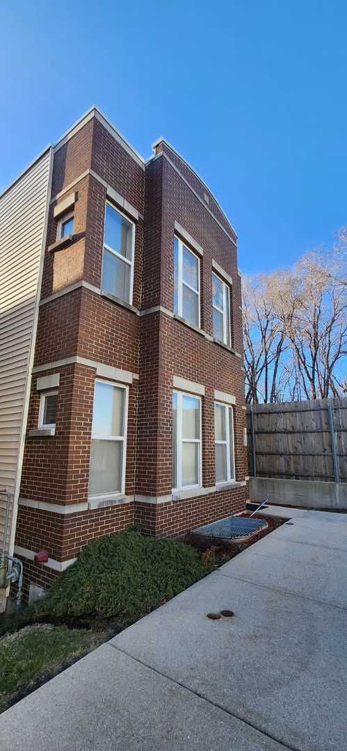 view of property exterior with brick siding and fence