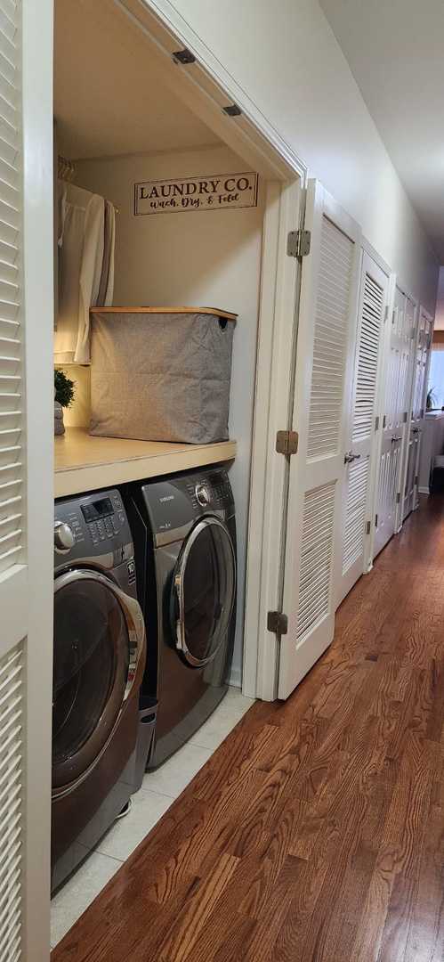 washroom featuring laundry area, washing machine and dryer, and light wood-type flooring
