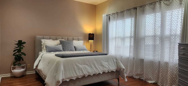 bedroom with baseboards and wood finished floors