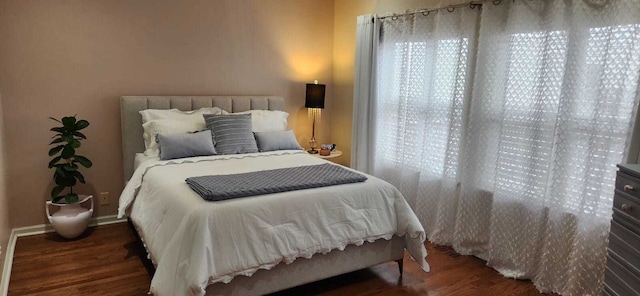 bedroom with baseboards and wood finished floors