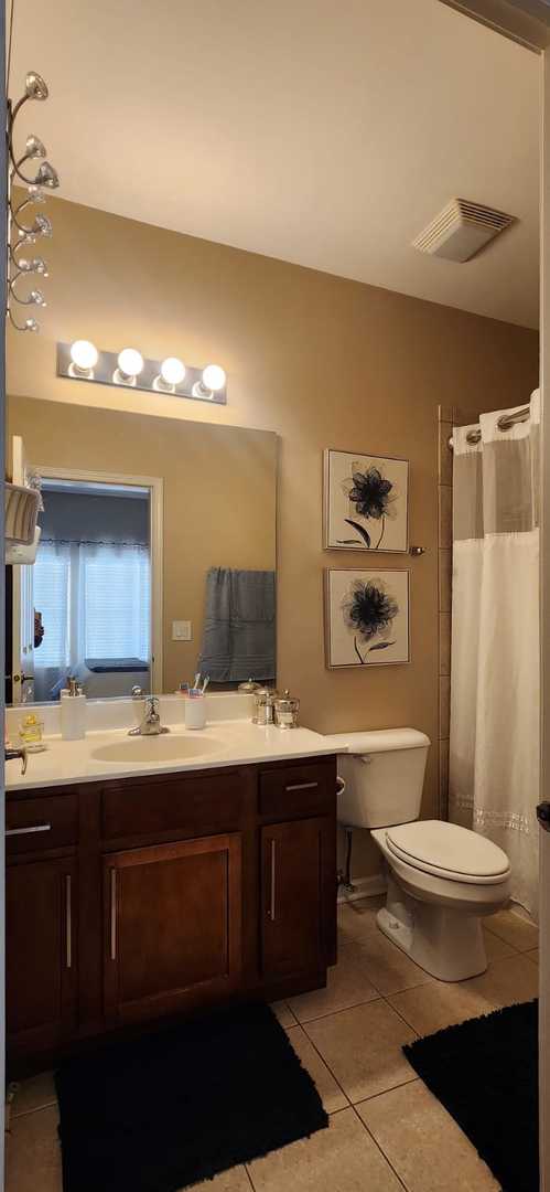 bathroom featuring tile patterned flooring, visible vents, vanity, toilet, and a shower with shower curtain