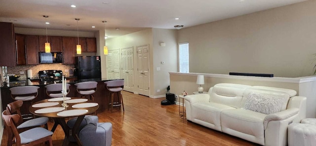 living area featuring recessed lighting, baseboards, and wood finished floors