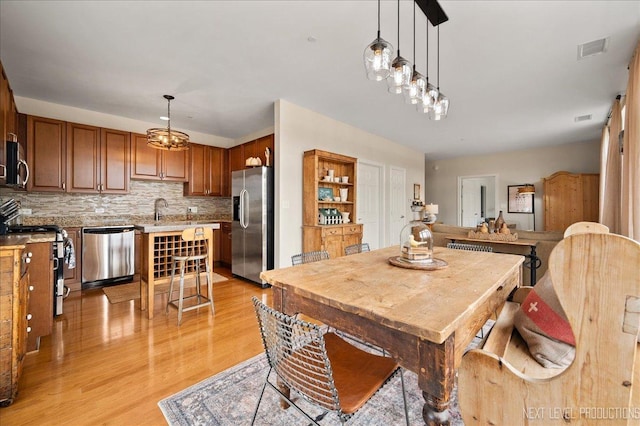 dining space featuring visible vents and light wood-style floors