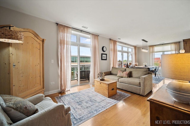 living room with light wood-style floors and visible vents