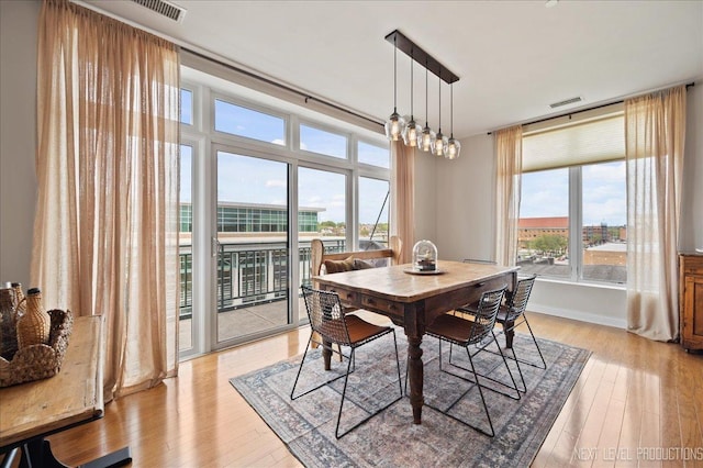 dining space with visible vents and light wood-type flooring