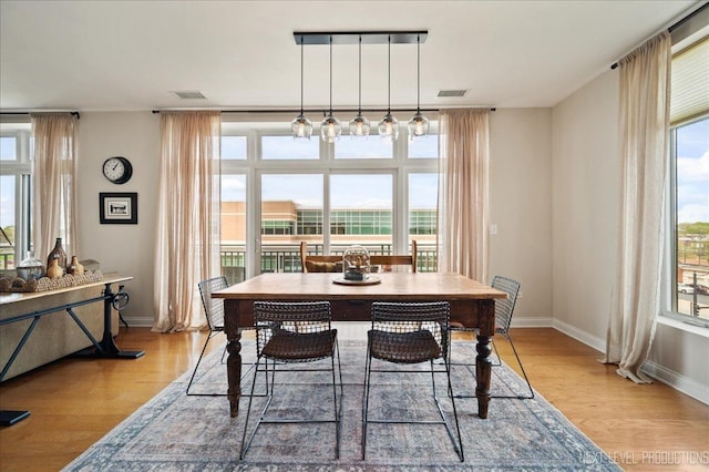 dining room with visible vents, baseboards, and light wood-type flooring
