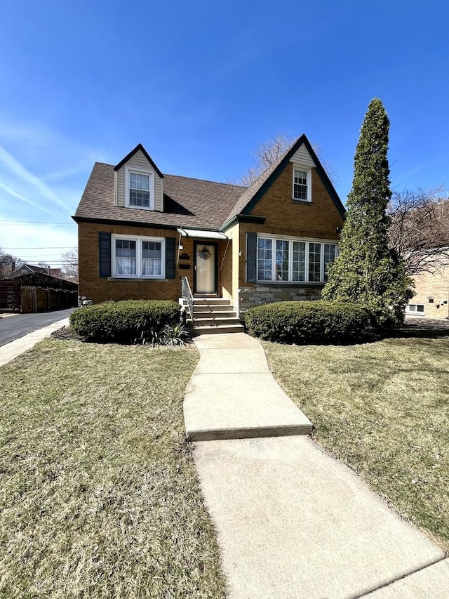 tudor home with a shingled roof and a front yard
