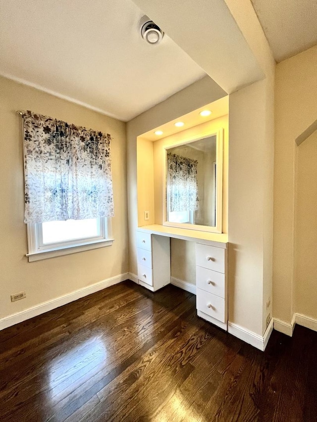 interior space featuring baseboards and wood finished floors