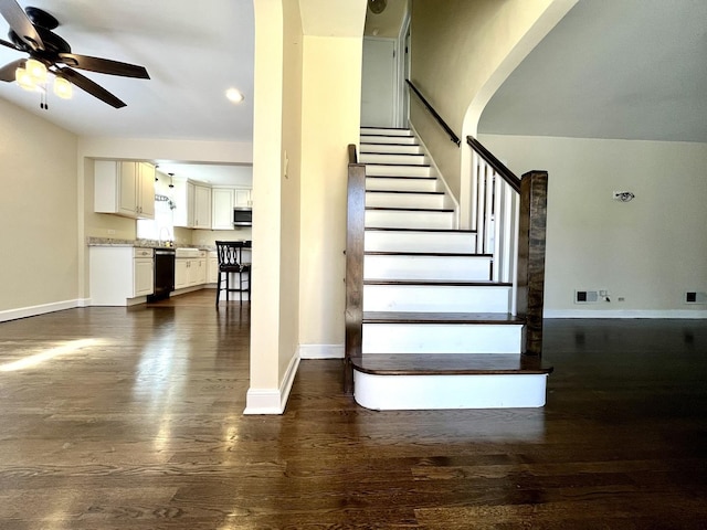 stairs with baseboards, ceiling fan, wood finished floors, and visible vents