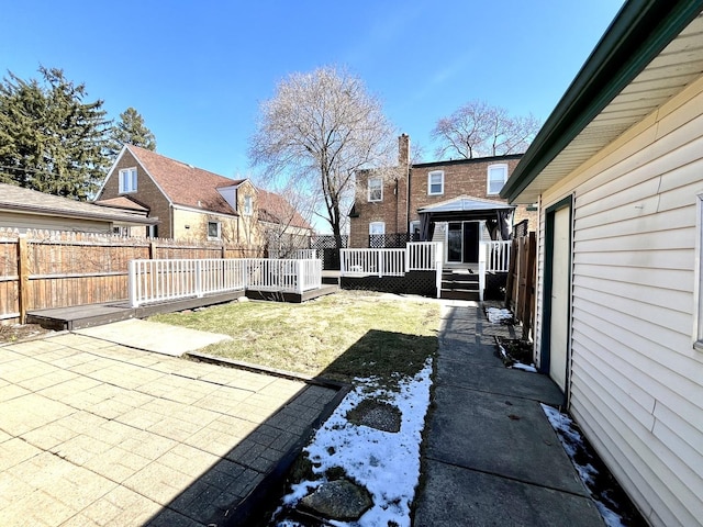 view of yard featuring a gazebo, fence, a wooden deck, and a patio area