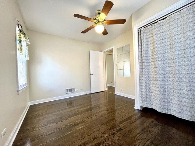 unfurnished bedroom with visible vents, baseboards, ceiling fan, and wood finished floors