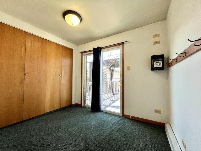 foyer entrance with baseboards, baseboard heating, and dark carpet