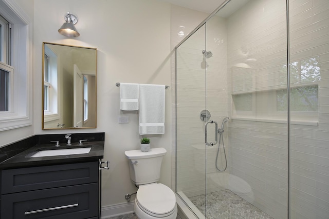 full bathroom featuring vanity, a stall shower, and toilet