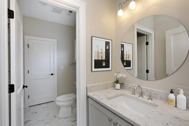 bathroom featuring visible vents, toilet, and vanity