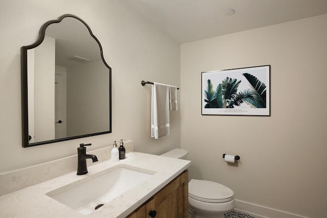 bathroom featuring toilet, baseboards, and vanity