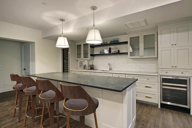 kitchen featuring dark wood-style flooring, a center island, tasteful backsplash, open shelves, and wine cooler