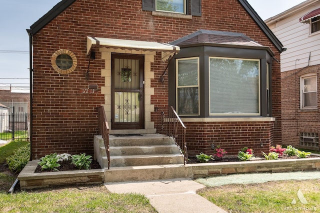 property entrance with brick siding and fence