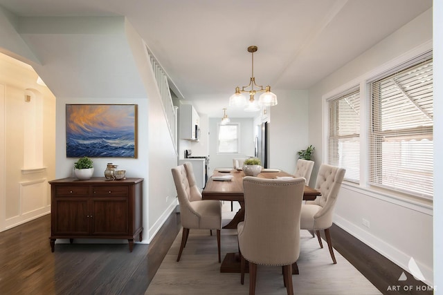 dining room with baseboards, an inviting chandelier, and dark wood-style floors