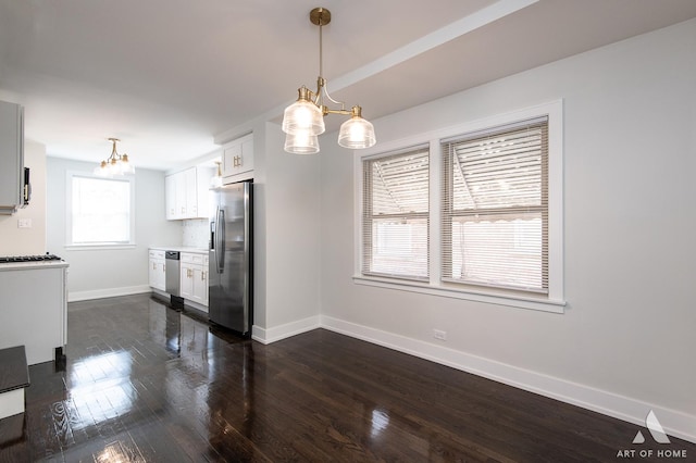 kitchen with baseboards, dark wood-style floors, white cabinets, a notable chandelier, and stainless steel appliances