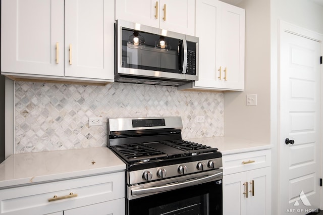 kitchen featuring backsplash, stainless steel appliances, and white cabinetry