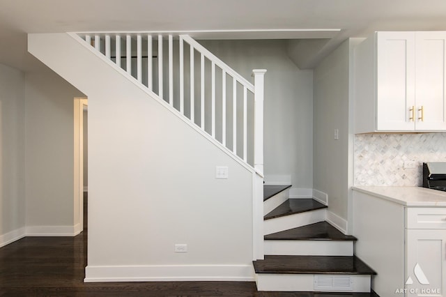 staircase featuring baseboards and wood finished floors