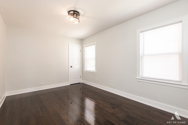 unfurnished room featuring baseboards, plenty of natural light, and dark wood-style floors