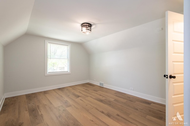 bonus room with visible vents, baseboards, lofted ceiling, and wood finished floors