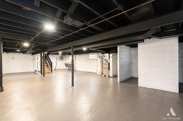 basement with heating unit, stairway, a sink, and visible vents