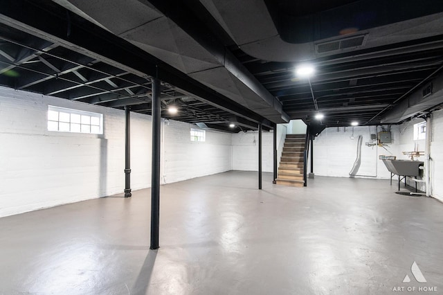 basement with visible vents, a sink, stairs, and a healthy amount of sunlight