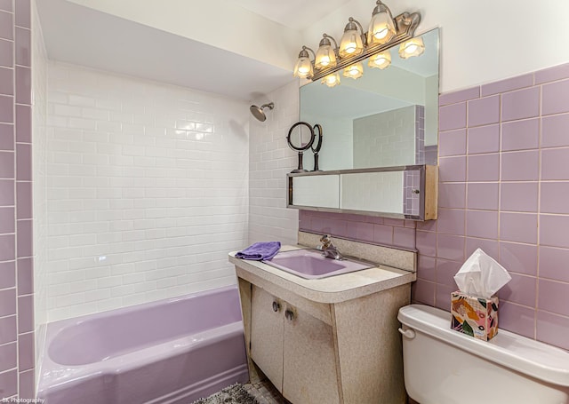 bathroom featuring tile walls, vanity, toilet, and shower / tub combination