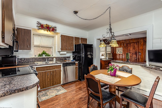 kitchen featuring stainless steel dishwasher, freestanding refrigerator, ornamental molding, dark countertops, and a sink