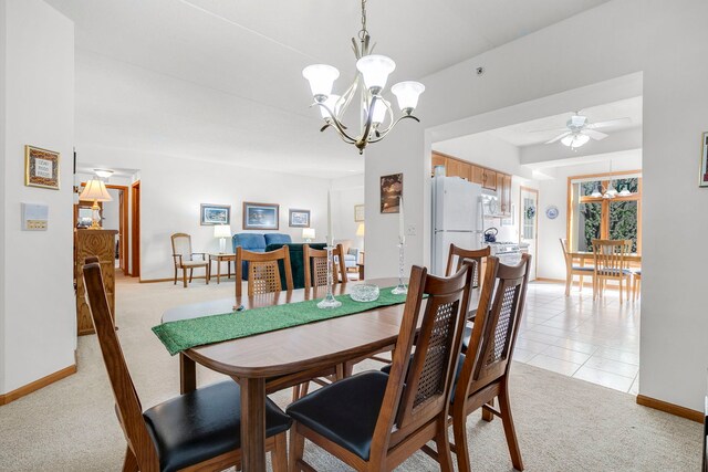 dining area with light colored carpet, baseboards, ceiling fan with notable chandelier, and light tile patterned floors