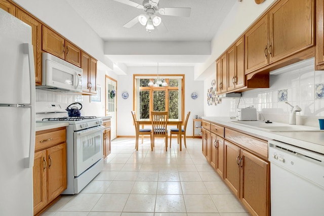 kitchen featuring a sink, decorative backsplash, a ceiling fan, and white appliances