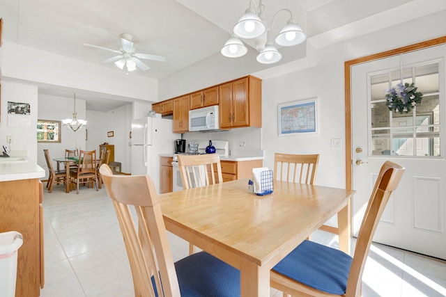 dining space featuring light tile patterned floors and ceiling fan with notable chandelier