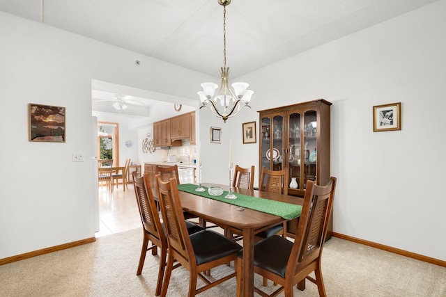 dining space featuring baseboards, light carpet, and ceiling fan with notable chandelier
