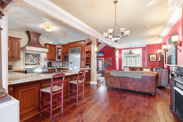 3842 N Alta Vista Ter, Chicago, IL 60613 - kitchen with premium range hood, a chandelier, built in appliances, a sink, and glass insert cabinets
