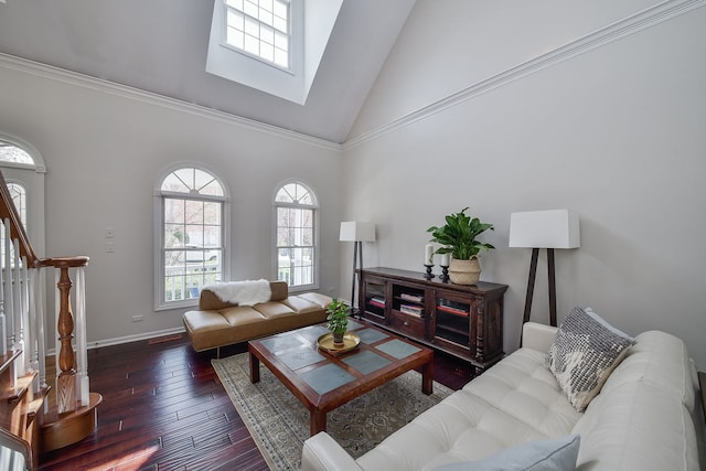living area featuring a skylight, stairway, high vaulted ceiling, baseboards, and hardwood / wood-style floors