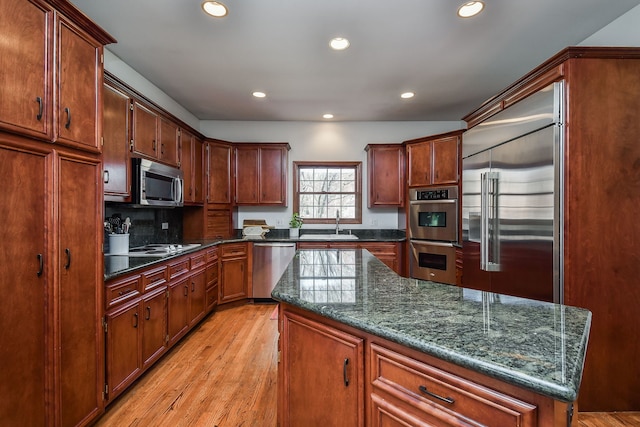kitchen with stainless steel appliances, recessed lighting, a sink, and light wood finished floors