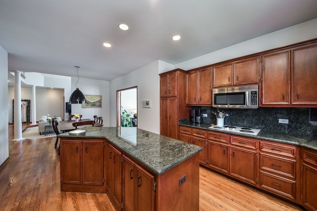 kitchen featuring ornate columns, white electric stovetop, light wood-style flooring, and stainless steel microwave