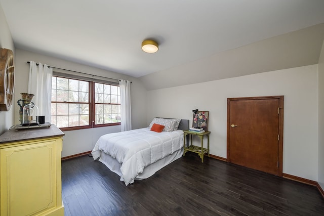 bedroom featuring baseboards, dark wood-style flooring, and vaulted ceiling