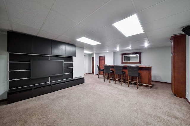 bar featuring baseboards, a dry bar, carpet, and a drop ceiling