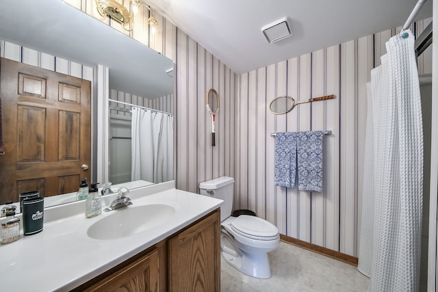 bathroom featuring vanity, baseboards, toilet, and wallpapered walls