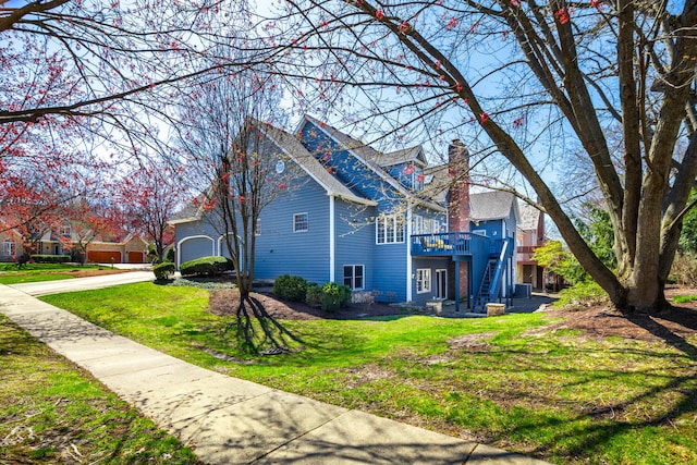 view of home's exterior with stairway, a deck, a yard, and a chimney
